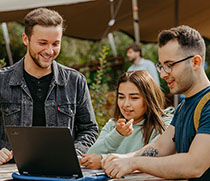 3 Menschen vor einem Laptop